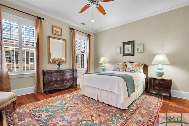 bedroom featuring baseboards, wood finished floors, and ornamental molding