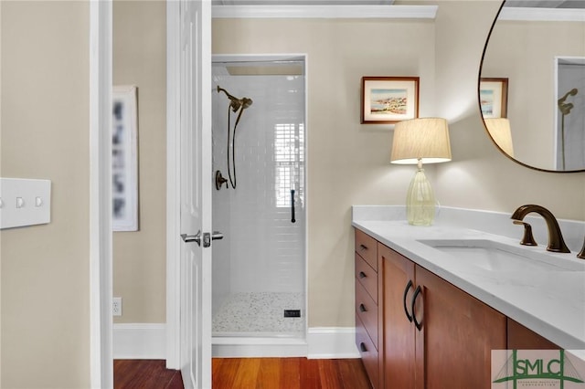 bathroom featuring a stall shower, vanity, baseboards, and wood finished floors