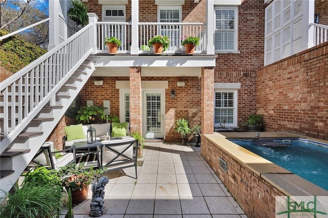 view of patio with stairway and a jacuzzi