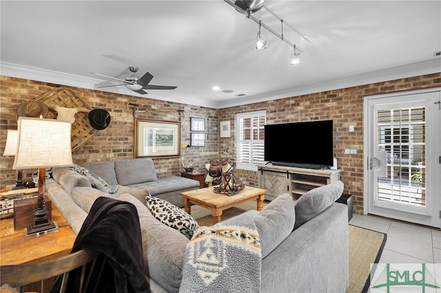 living area featuring tile patterned flooring, brick wall, rail lighting, and a ceiling fan