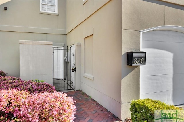 doorway to property with a gate and stucco siding