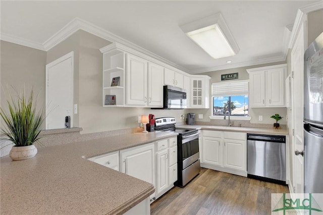 kitchen featuring white cabinetry, crown molding, appliances with stainless steel finishes, and a sink