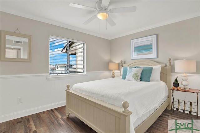 bedroom with ceiling fan, ornamental molding, wood finished floors, and wainscoting