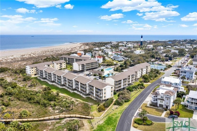 birds eye view of property with a water view and a beach view