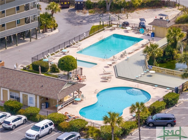 community pool featuring a patio area and fence