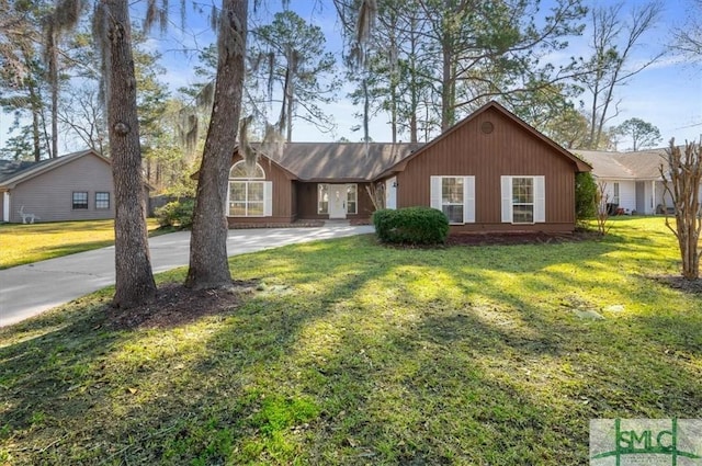 ranch-style house with concrete driveway and a front lawn