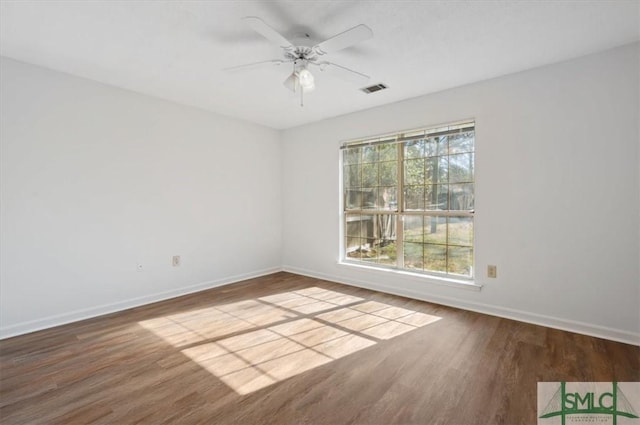 empty room with visible vents, baseboards, and wood finished floors