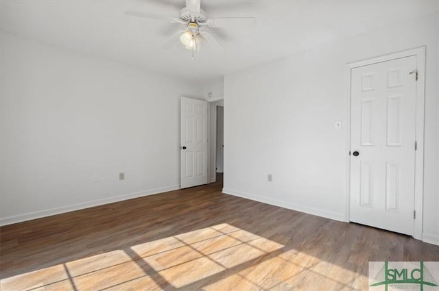 spare room with baseboards, a ceiling fan, and wood finished floors