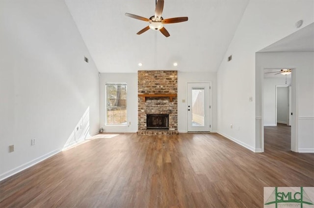 unfurnished living room with wood finished floors, a brick fireplace, a ceiling fan, and baseboards