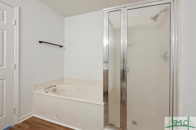 full bathroom featuring a shower stall and a bath