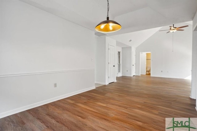 unfurnished room featuring wood finished floors, a ceiling fan, baseboards, and lofted ceiling