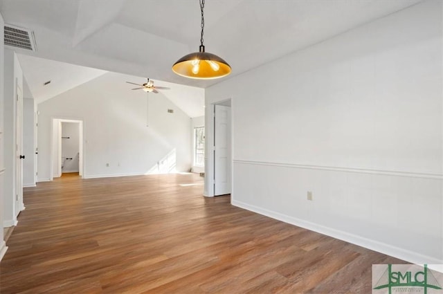 empty room with lofted ceiling, light wood-style flooring, visible vents, and ceiling fan