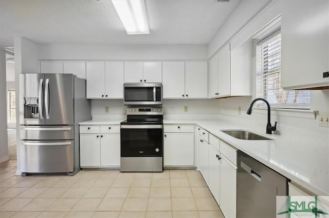 kitchen with white cabinetry, light countertops, appliances with stainless steel finishes, and a sink