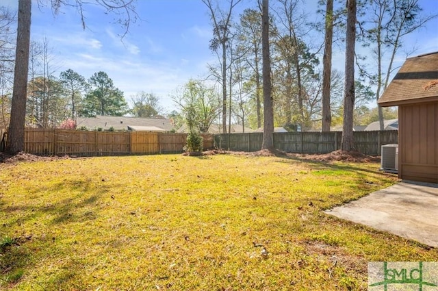 view of yard with a fenced backyard and central AC