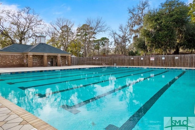 pool with a patio area and fence