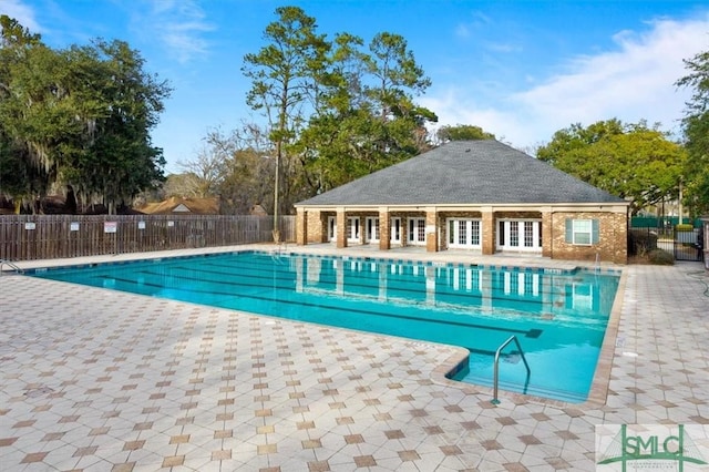 community pool with french doors, a patio, and fence