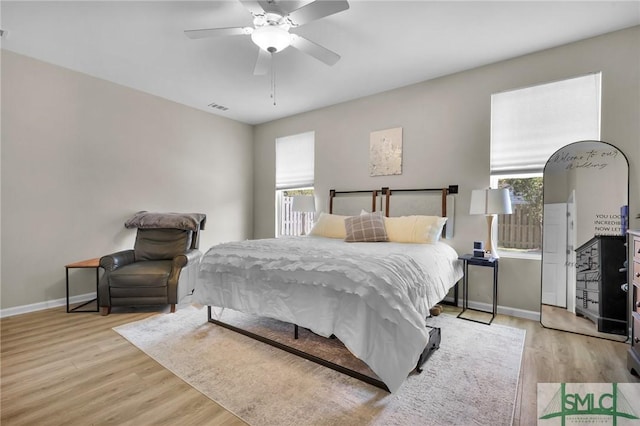 bedroom featuring a ceiling fan, visible vents, baseboards, and light wood-type flooring