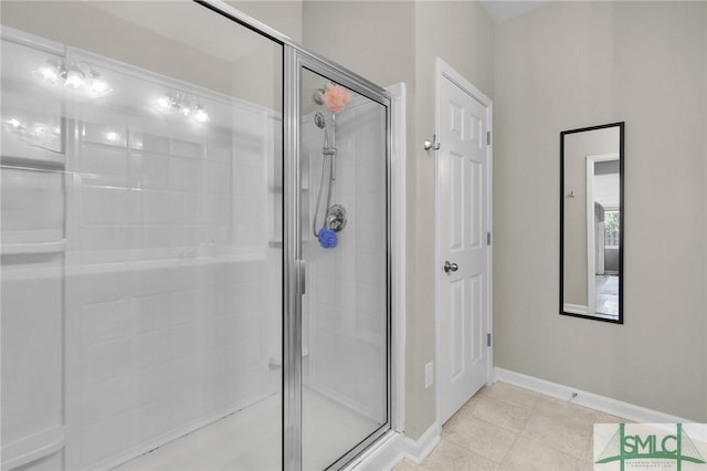 bathroom with a shower stall, baseboards, and tile patterned floors