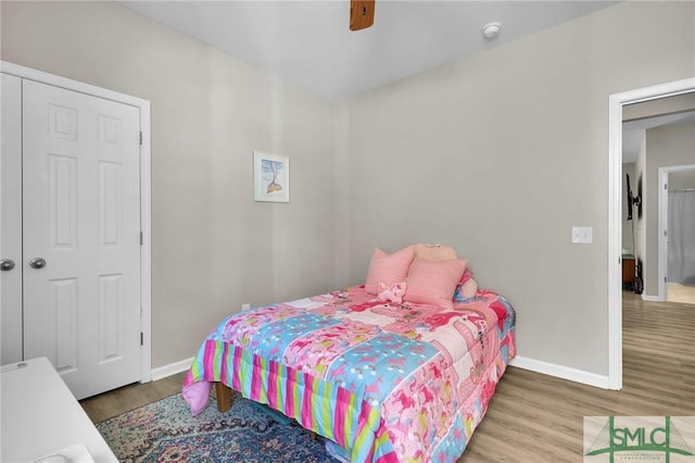 bedroom with ceiling fan, baseboards, and wood finished floors