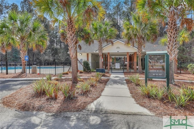 exterior space with a fenced front yard and a swimming pool