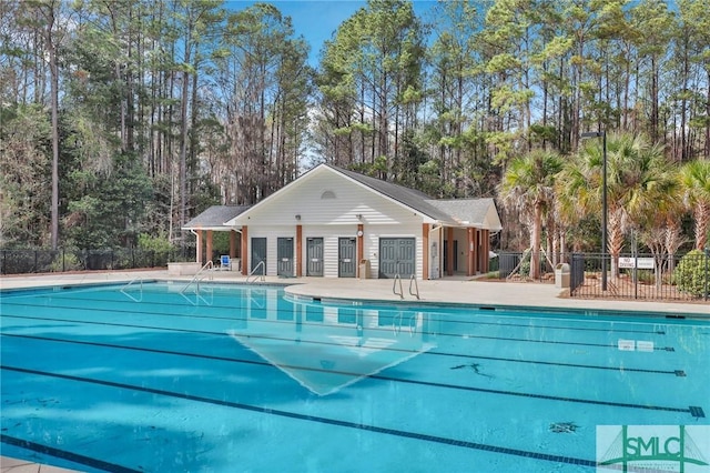 community pool with a patio area and fence