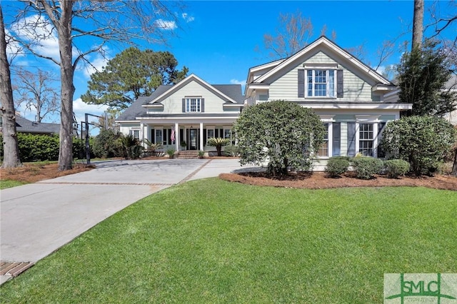 view of front of property featuring concrete driveway and a front yard