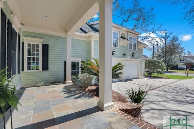 view of patio with concrete driveway and a garage