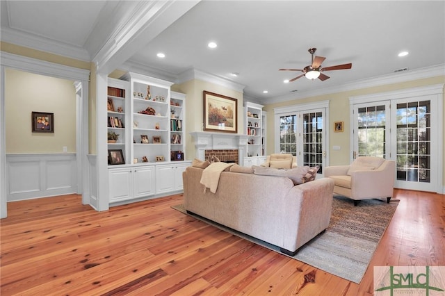 living area featuring ornamental molding, recessed lighting, a fireplace, light wood-style floors, and a ceiling fan