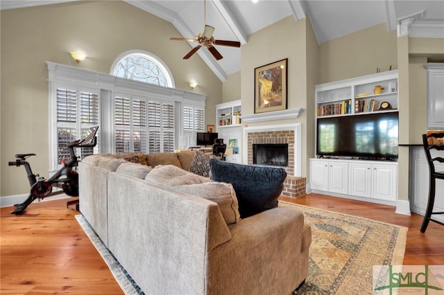 living room featuring a brick fireplace, baseboards, wood finished floors, high vaulted ceiling, and a ceiling fan