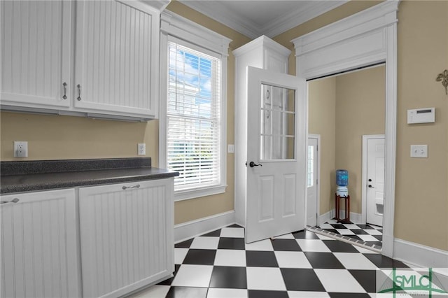 entryway with tile patterned floors, baseboards, and ornamental molding