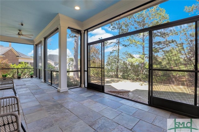 unfurnished sunroom featuring ceiling fan