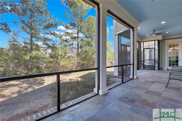 unfurnished sunroom with ceiling fan