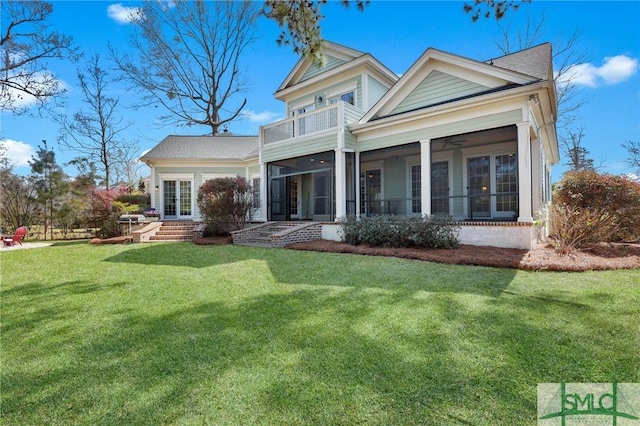 back of house with a yard, french doors, a balcony, and a sunroom