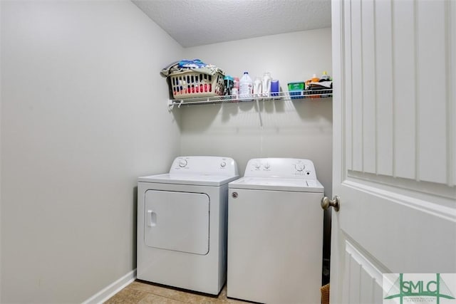 laundry room featuring washer and clothes dryer, laundry area, a textured ceiling, and baseboards