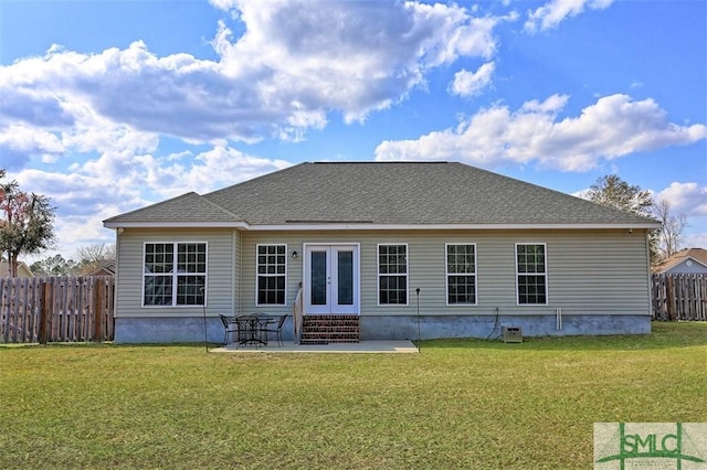 rear view of house featuring a patio, a shingled roof, entry steps, fence private yard, and a lawn