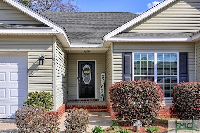 view of exterior entry with a shingled roof