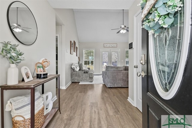 entrance foyer with lofted ceiling, wood finished floors, a ceiling fan, and french doors