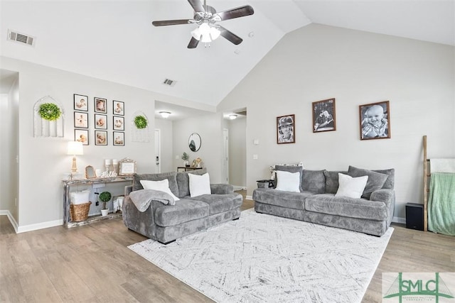 living area with light wood-type flooring, visible vents, high vaulted ceiling, and ceiling fan