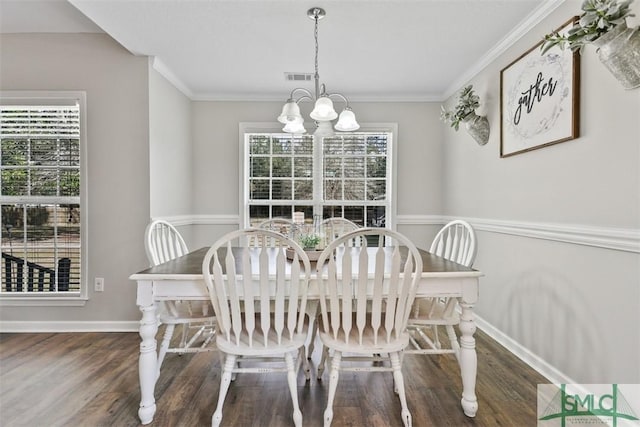 dining area featuring a chandelier, visible vents, ornamental molding, and wood finished floors