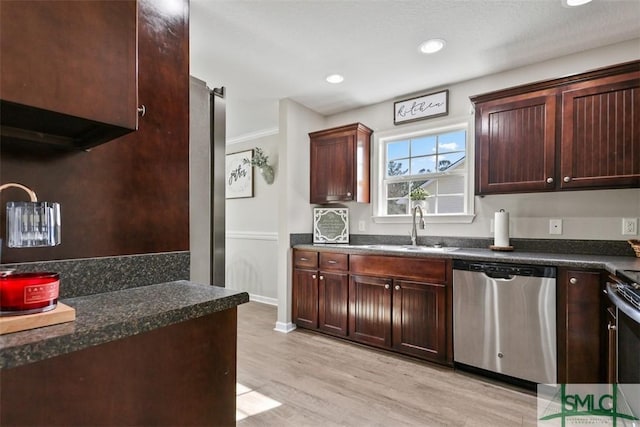 kitchen with dark countertops, a sink, and stainless steel dishwasher