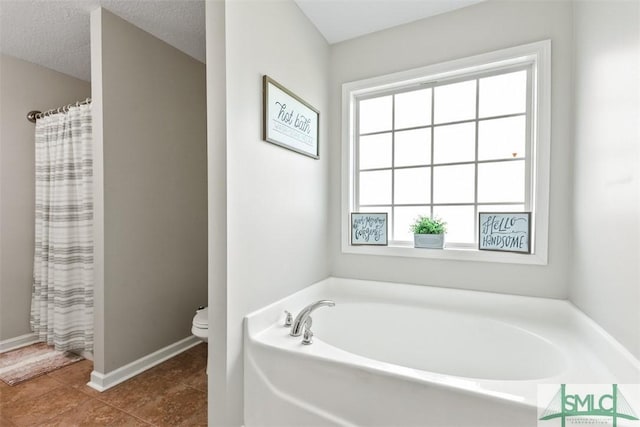 full bath featuring baseboards, a garden tub, toilet, and tile patterned flooring