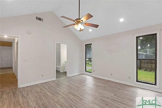 unfurnished bedroom featuring visible vents, high vaulted ceiling, wood finished floors, connected bathroom, and baseboards