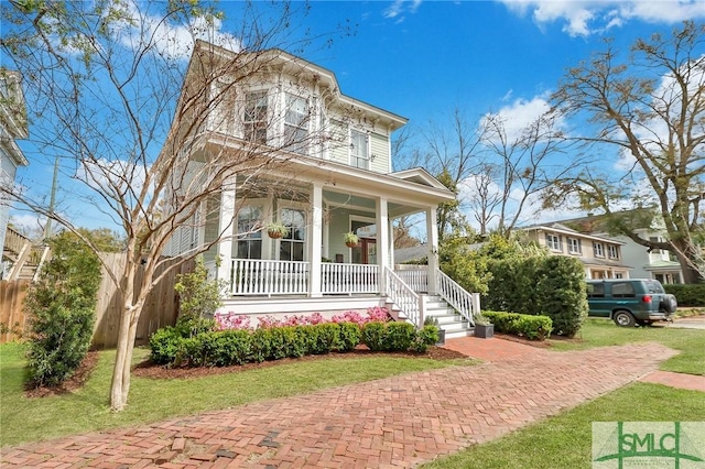 italianate home featuring covered porch and a front yard