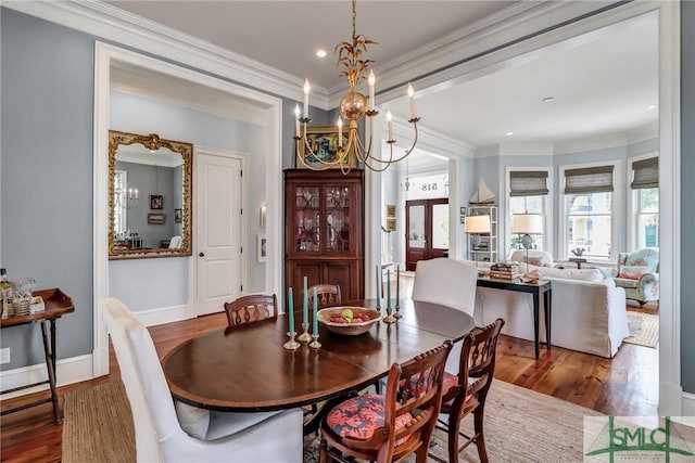 dining area with crown molding, an inviting chandelier, and wood finished floors