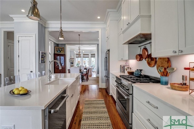 kitchen with dark wood-type flooring, white cabinetry, appliances with stainless steel finishes, light countertops, and a chandelier