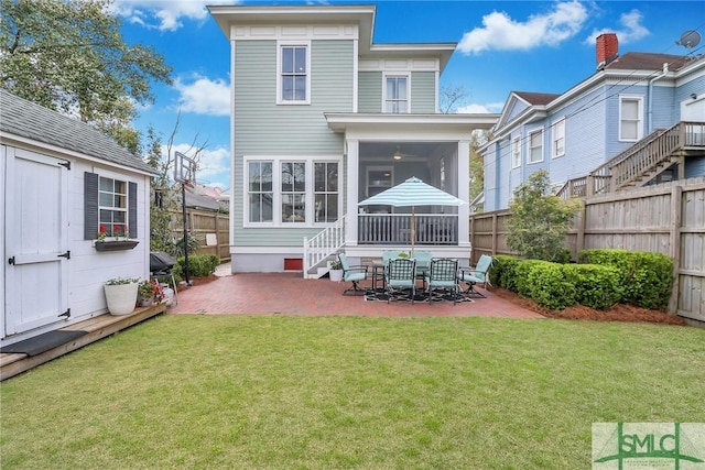 rear view of house with a lawn, a patio, a fenced backyard, and a sunroom