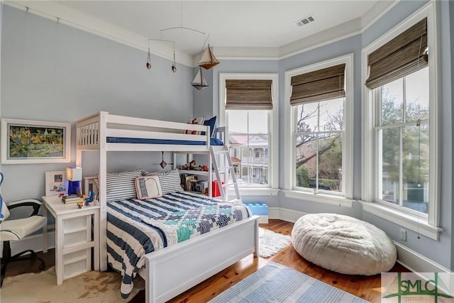 bedroom featuring wood finished floors, baseboards, and visible vents