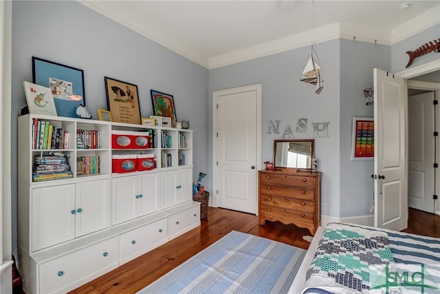 bedroom with wood finished floors and ornamental molding