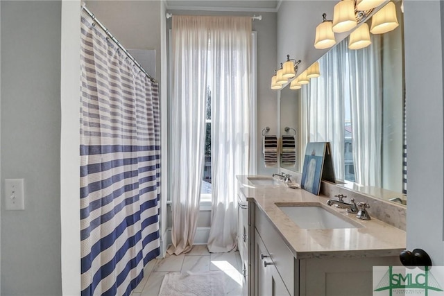 bathroom with curtained shower, double vanity, a notable chandelier, and a sink