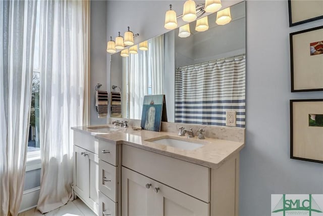 bathroom featuring double vanity, a shower with shower curtain, an inviting chandelier, and a sink